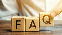 Hand places wooden cubes with the letters FAQ