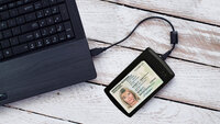 ID card lies on USB card reader, which is connected to the laptop