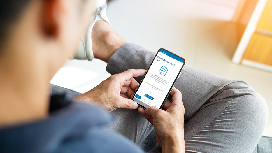 Man holding smartphone with AusweisApp open at Check device and ID card function